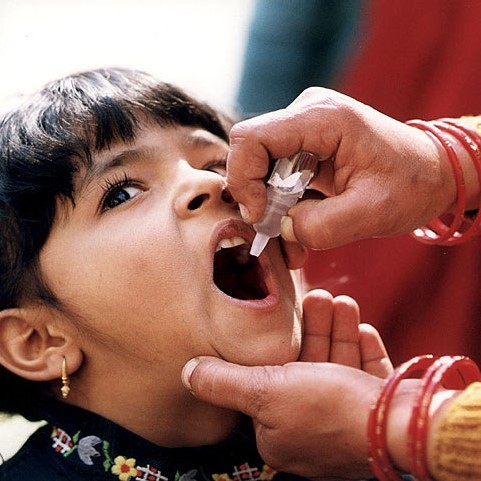 A girl opens her mouth to receive an oral vaccination.
