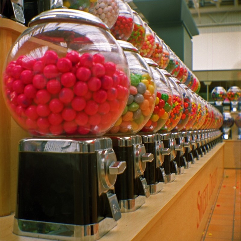 A row of coin-operated gumball machines.