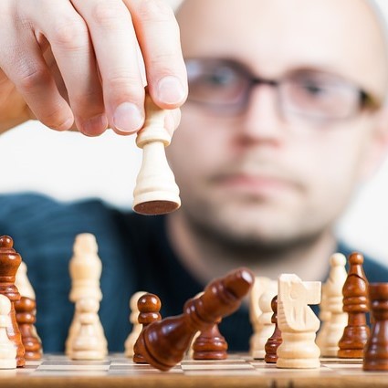 A man makes a chess move.