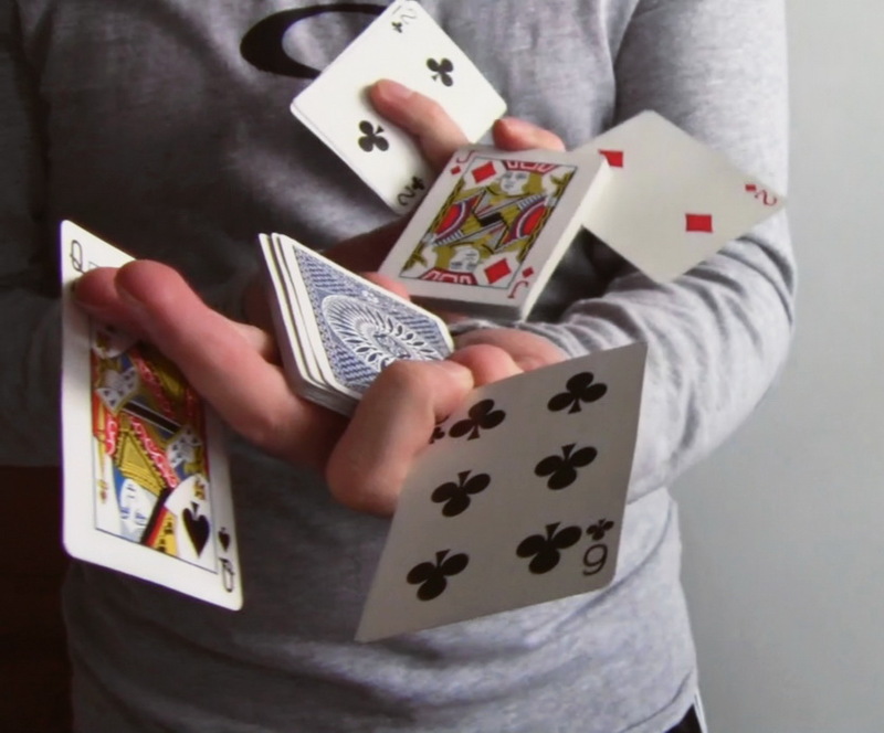 A magician manipulates a deck of cards.