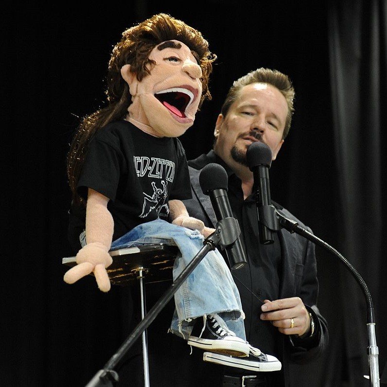 A ventriloquist performs on stage.