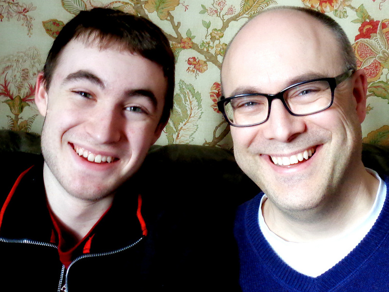 A teen son and his father with a strong family resemblance. 