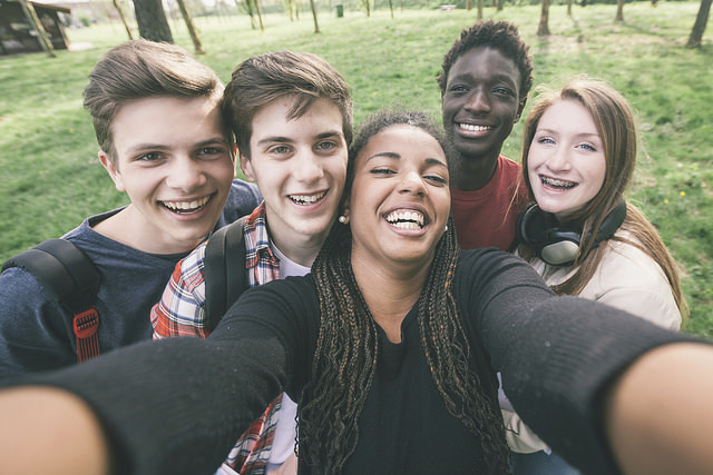 A group of Generation Z students pose for a group selfie.