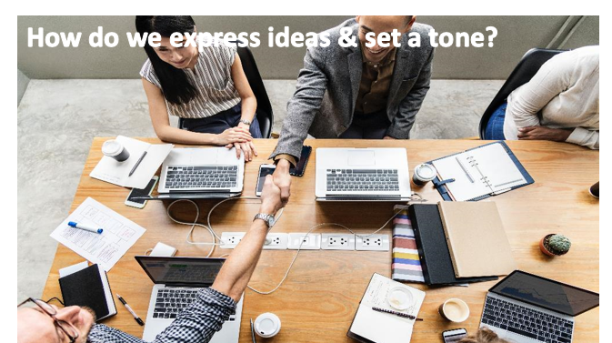 An image of people sitting around the table, two of the people are sitting across the table from each other and shaking hands. An image caption reads: "How do we express ideas & set a tone?"