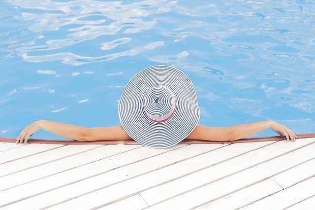 A person lounging by the pool in a hat