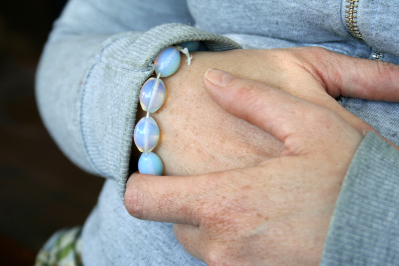 A close up of a woman clutching her hands together.