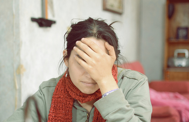 A woman covers her face in embarrassment. 