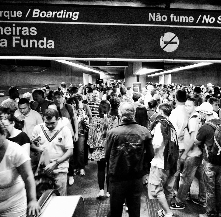 Una estación de tren abarrotada con arroyos de personas que pasan en direcciones opuestas.