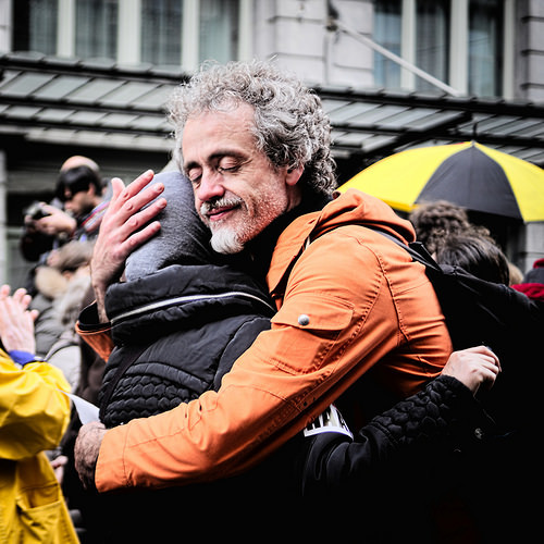 A man and woman embrace in the street.