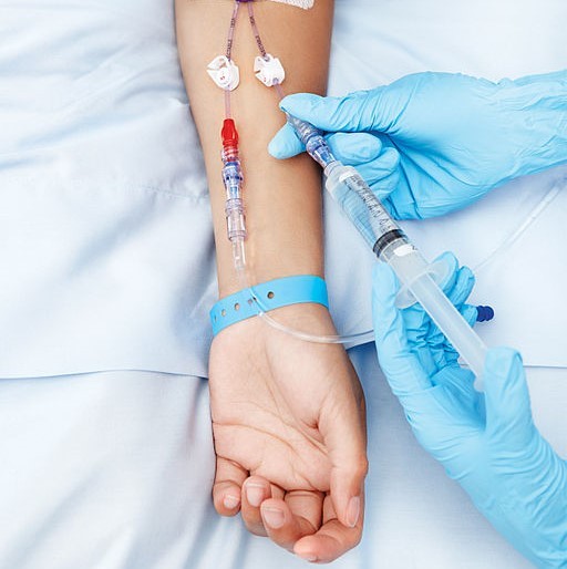 Close up of a patient arm fitted with an IV drip.
