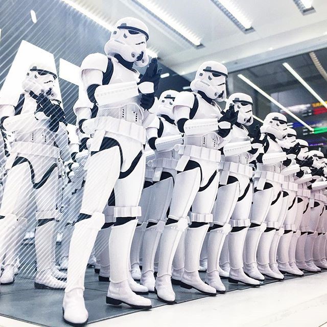 Una línea de stormtroopers vestidos de manera idéntica de las películas de Star Wars.