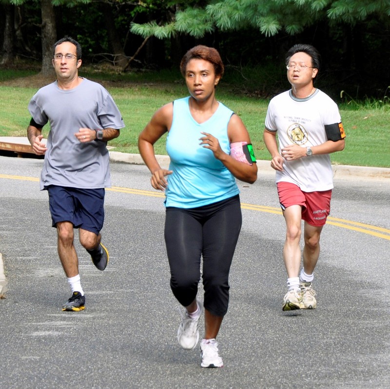 A group of joggers running through a park. A group of joggers running through a park.