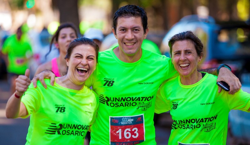 Teammates in matching shirts celebrate together at the end of a marathon.