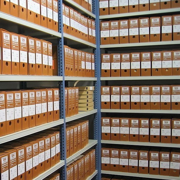 Archive shelves full of document binders.