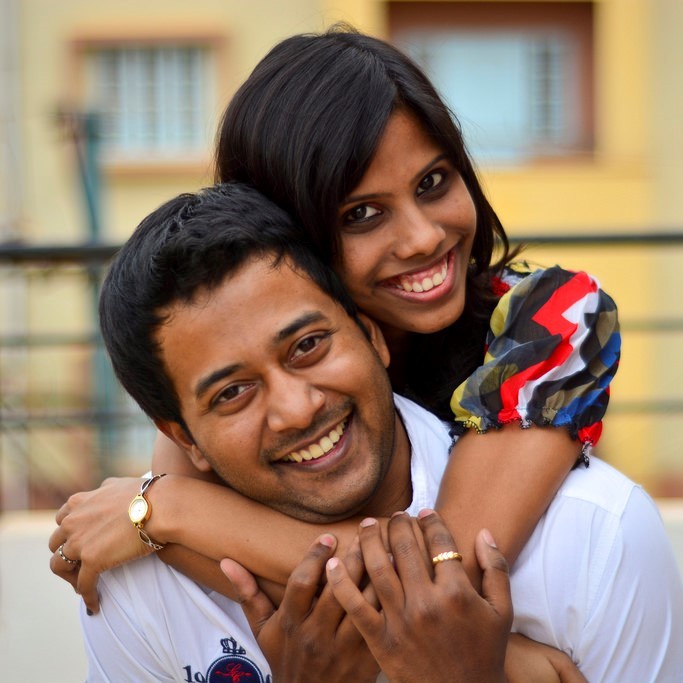 A happy couple embrace and smile broadly.