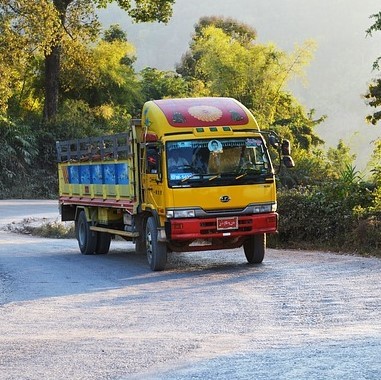 A colorful transport truck driving up a hill.