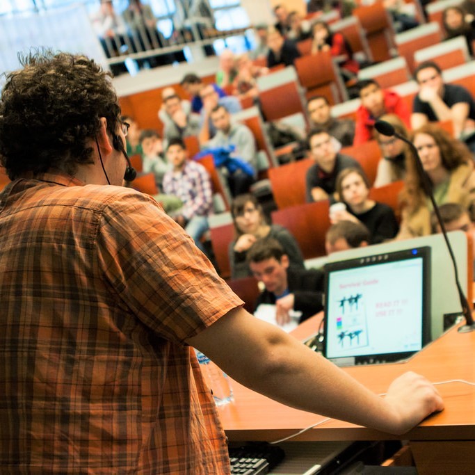 An instructor lectures a group of college students.