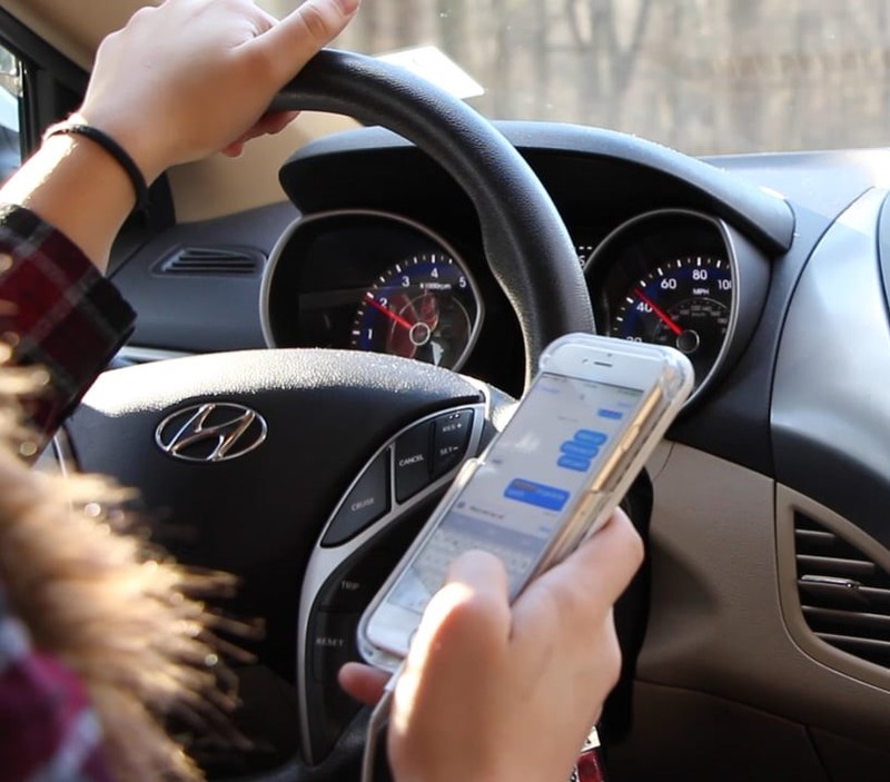 A woman texting as she drives.