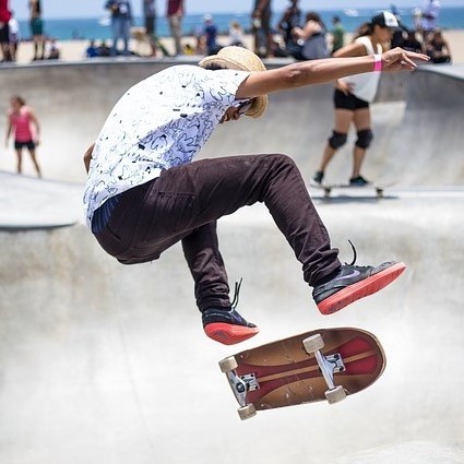 A skateboarder performs a trick at a skate park.