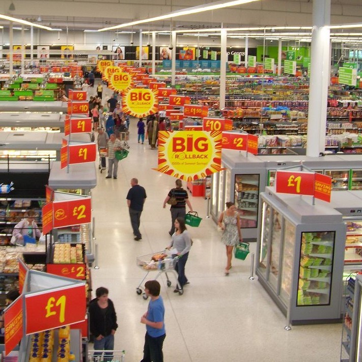 View of a modern supermarket with many aisles full of thousands of products and many hundreds of bright signs with product information. View of a modern supermarket with many aisles full of thousands of products and many hundreds of bright signs with product information.