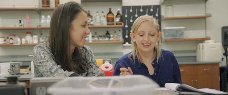 A nursing student works in a lab with a faculty mentor.