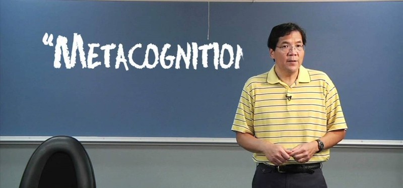 Dr. Chew stands in front of a board in a classroom with the word 'metacognition' written on it.