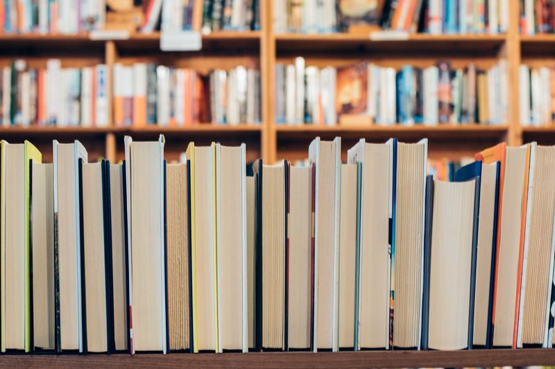 Books stacked on a shelf with their spines turned away from the viewer