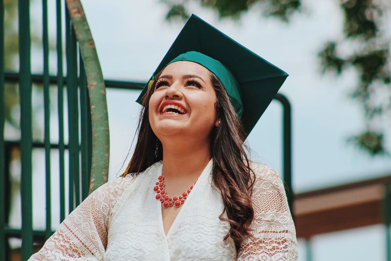 A student wearing a graduation cap and smiling