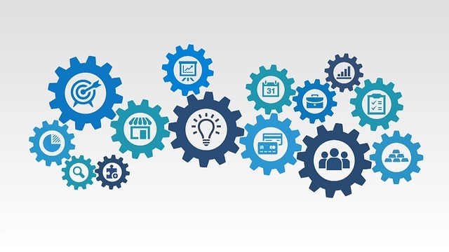 An image depicting gears that are interlocked that contain various items inside them. The items include: a puzzle piece, a magnifying glass, a pie chart, a dartboard with an arrow, a building, a light bulb, a graph, payment cards, calendar, briefcase, people, building blocks, check-off list, and a bar chart. 