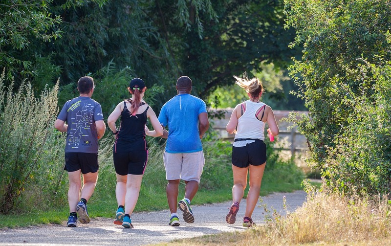 Four people jogging in a park